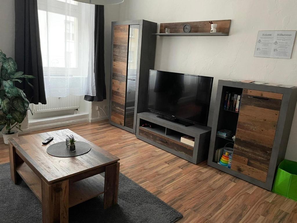 Televízia a/alebo spoločenská miestnosť v ubytovaní Wohnen in Loriot’s Wasserstadt mit Kamin