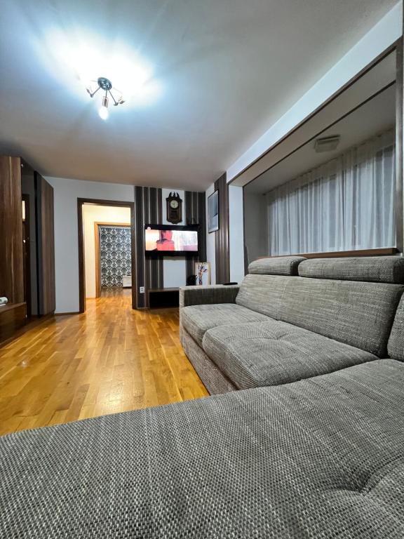 a living room with two couches and a flat screen tv at Debo Apartament in Lugoj