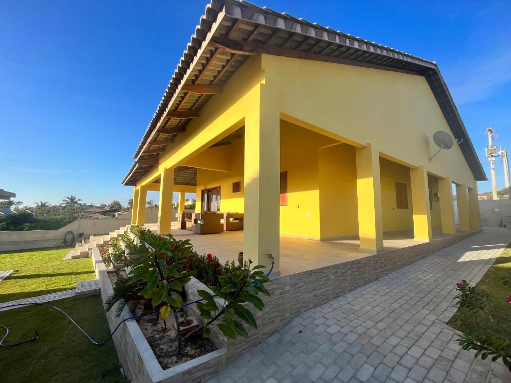 ein kleines Haus mit einer Terrasse davor in der Unterkunft Villa Amarelo in Beberibe