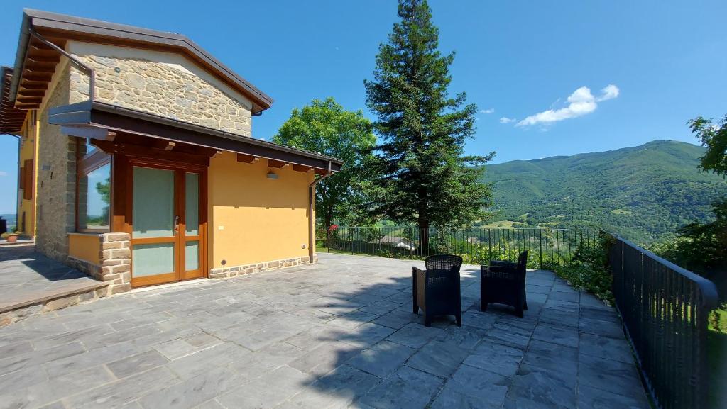 ein Haus mit einer Terrasse mit einem Zaun und Bergen in der Unterkunft B&B Santa Croce 248 in Fanano