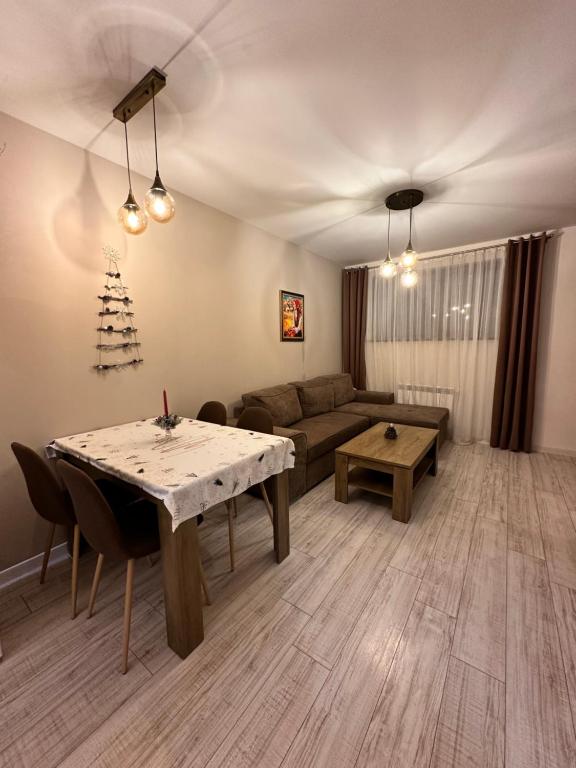 ein Wohnzimmer mit einem Tisch und einem Sofa in der Unterkunft Petkovi Аpartments, Borovets Gardens - One-bedroom and Two-bedroom apartments in Borowez
