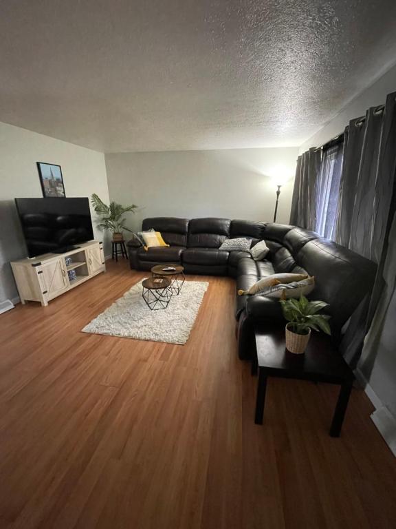 ein Wohnzimmer mit einem schwarzen Ledersofa in der Unterkunft Quiet & Cozy home near Hospitals in Cleveland