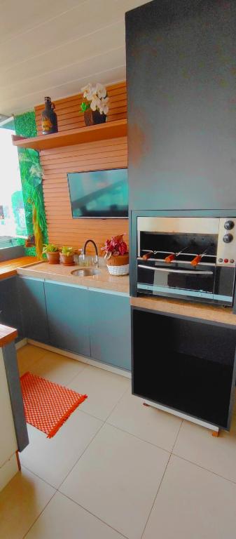 a kitchen with a stove and a sink in it at Vista incrível na melhor localização da praia da costa in Vila Velha