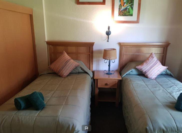two beds sitting next to each other in a room at Fairways resort 6 sleeper unit in Drakensberg Garden