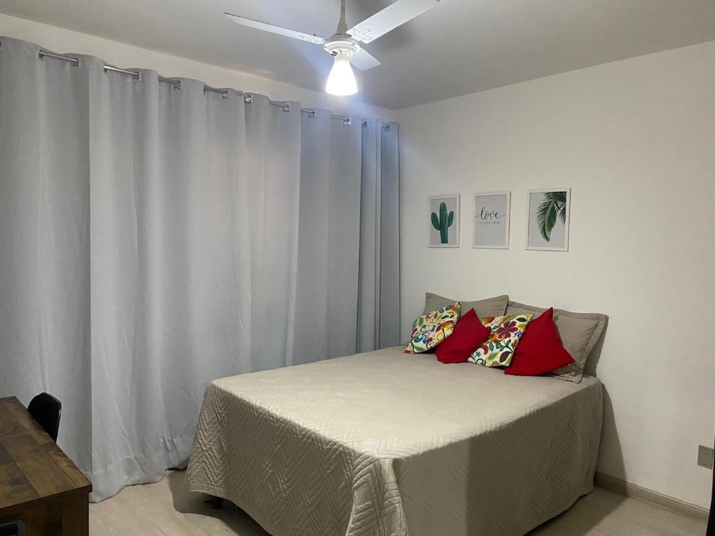 a bedroom with a bed with a ceiling fan at Apartamento grande 900m do centro in Diamantina