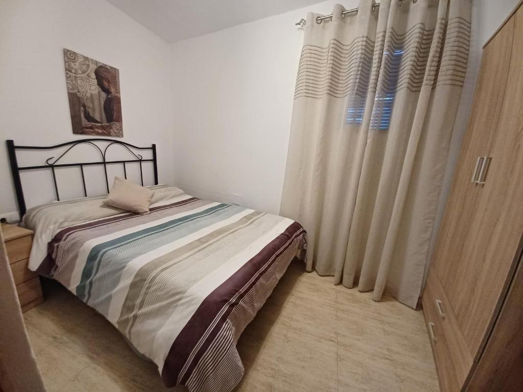 1 dormitorio con 1 cama y una ventana con cortinas en Casa Diego. Algodonales (Cadiz), en Algodonales