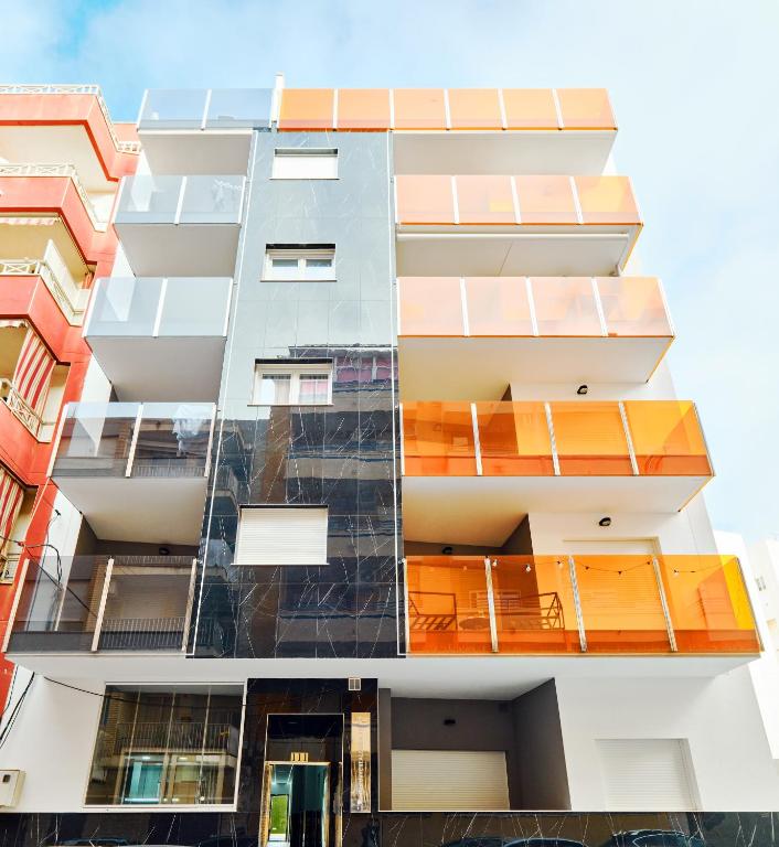 a tall building with orange balconies on it at Centro Modern Beach & Spa in Torrevieja