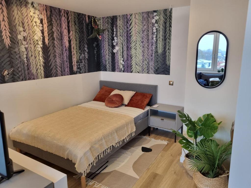 a small bedroom with a bed and a mirror at Apartament Spokojna przy SUNTAGO DEEPSPOT Mszczonów in Mszczonów