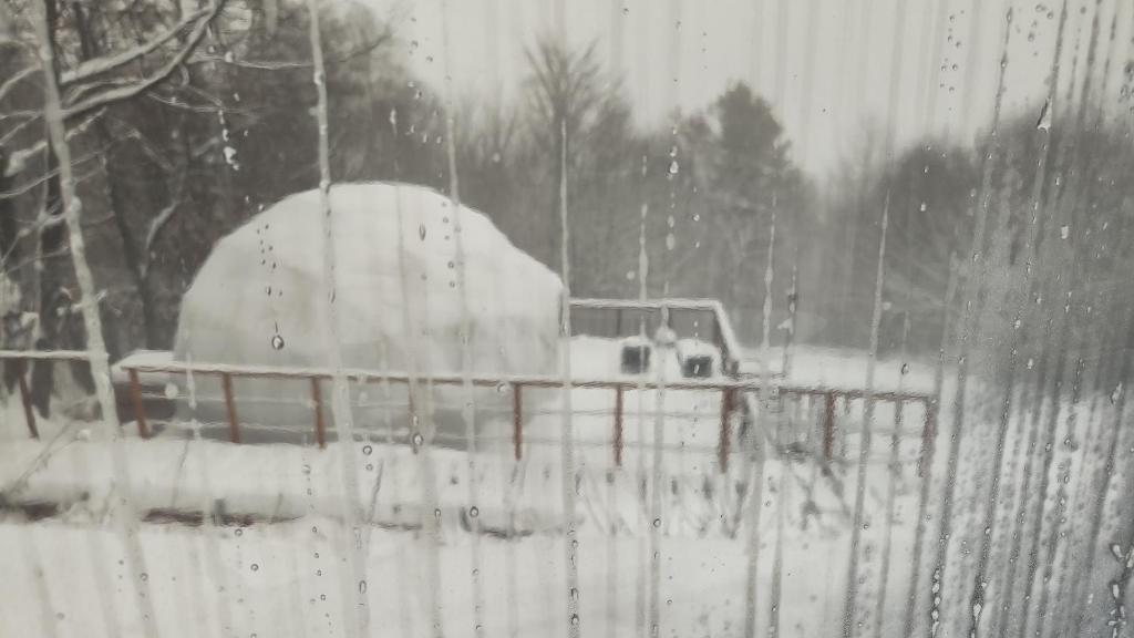 a truck is covered in snow behind a fence at ENERGY GLAMP in Międzybrodzie Bialskie