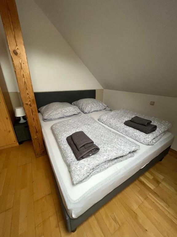 a bed with white sheets and black towels on it at MWM Gästehaus -Zimmer in Meine