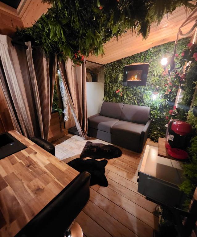 un salon avec un canapé et une table dans l'établissement INDIANA JONES à 10 minutes du Parc Disneyland (taille chambre), à Condé-Sainte-Libiaire