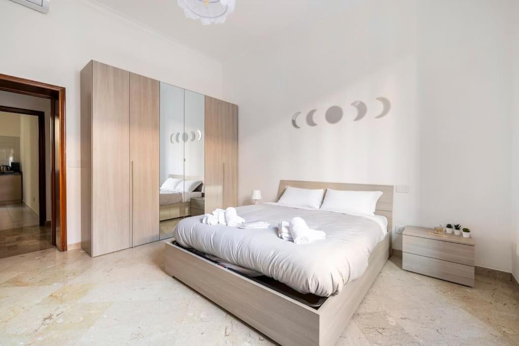 een slaapkamer met een groot bed met witte lakens bij Casa amoR in Trastevere in Rome