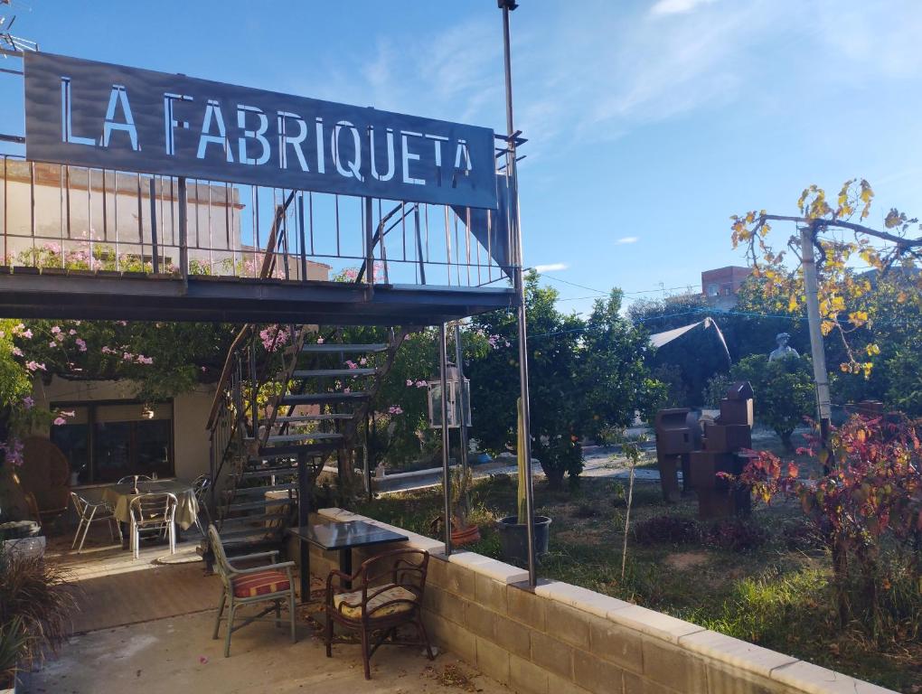 a sign for a restaurant with a table and chairs at La Fabriqueta Suite in Ríudecañas