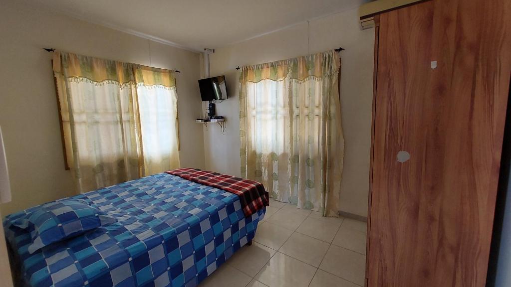 a bedroom with a bed and a tv in it at Apartment Julia in Paramaribo