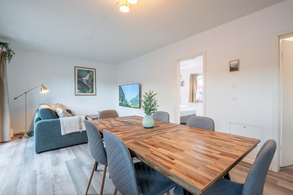 uma sala de jantar e sala de estar com uma mesa de madeira e cadeiras em Moderne Wohnung mit Parkplatz - Top Floor em Ostermundigen