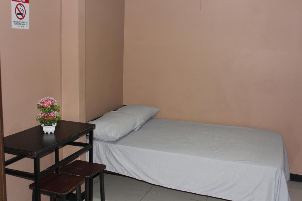 um pequeno quarto com uma cama e uma mesa em Hotel Pecos Bill em San José