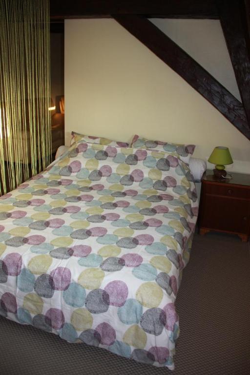 Una cama con un edredón colorido en un dormitorio en Chez Sabine et Laurent, en Saverne