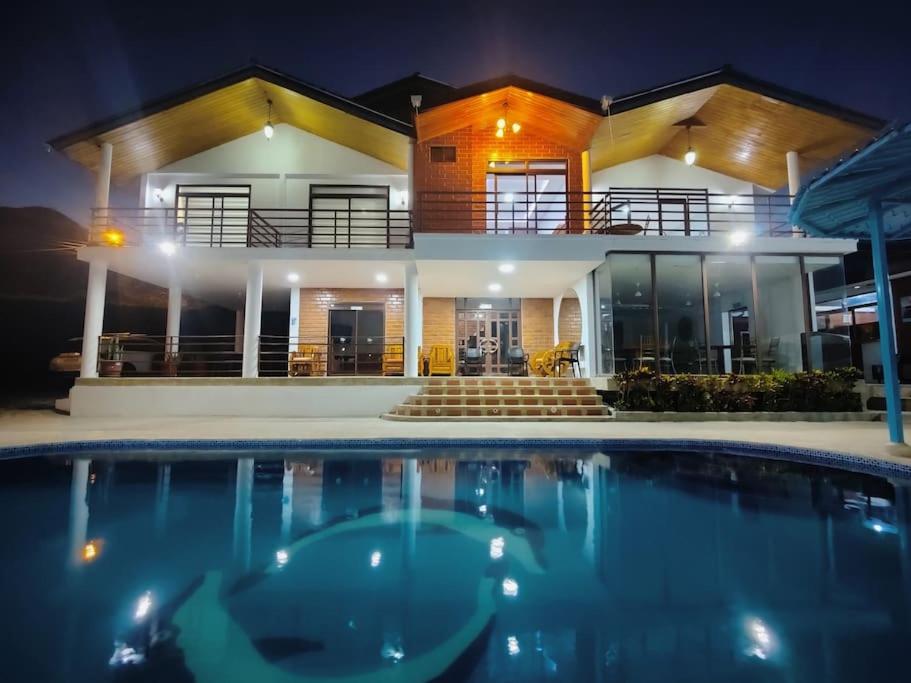 una casa con piscina frente a ella en Hostería Quinta Esperanza - Alquiler del Alojamiento Entero en Loja