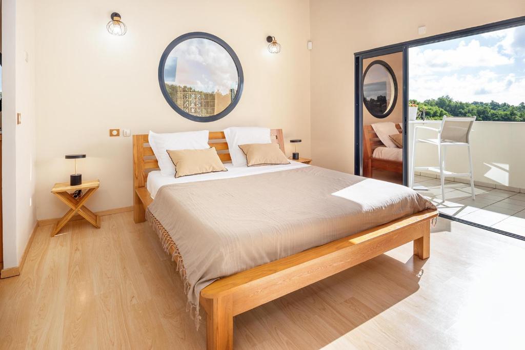 a bedroom with a large bed with a large window at Villa Galba in Le Gosier