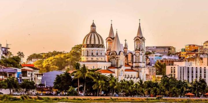 a large white building with towers on a city at Rua do cacau in Ilhéus