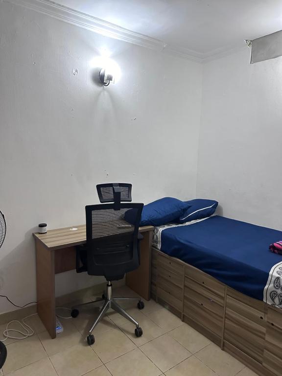 1 dormitorio con escritorio, 1 cama y 1 silla en Jacob Mews Estate, en Lagos