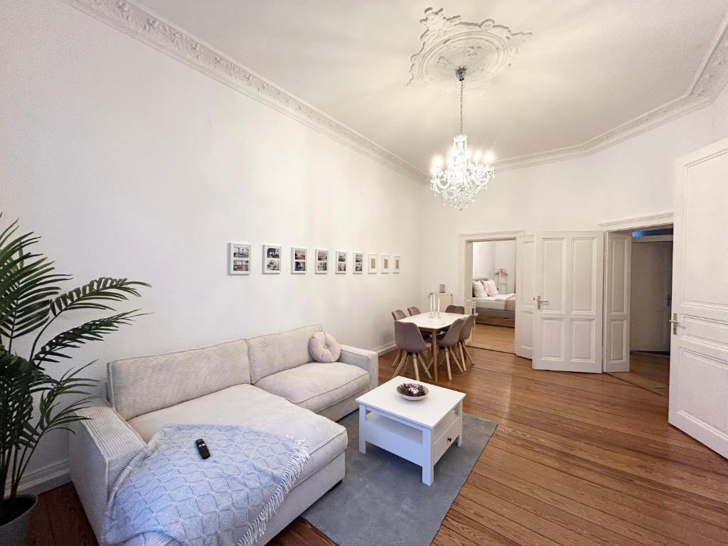 een woonkamer met een bank en een tafel bij IDEE Living: Traumhaftes Altbau Apartment - Balkon in Wiesbaden