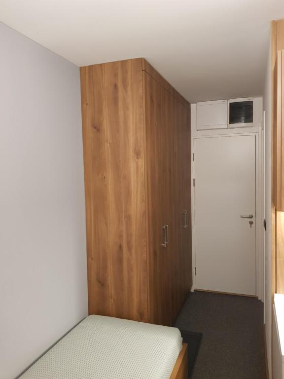a small bedroom with a bed and a wooden cabinet at PAHULJA Apartman Kopaonik Brzeće in Brzeće