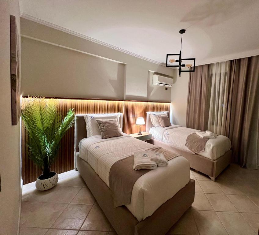 Spacious City Paradise - 3BR Apt in the Heart of Tirana في تيرانا: غرفه فندقيه سريرين ومصنع