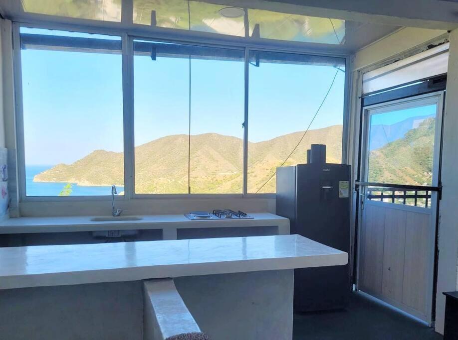 a kitchen with a large window and a refrigerator at Apartaestudio en la Montaña de Taganga in Santa Marta