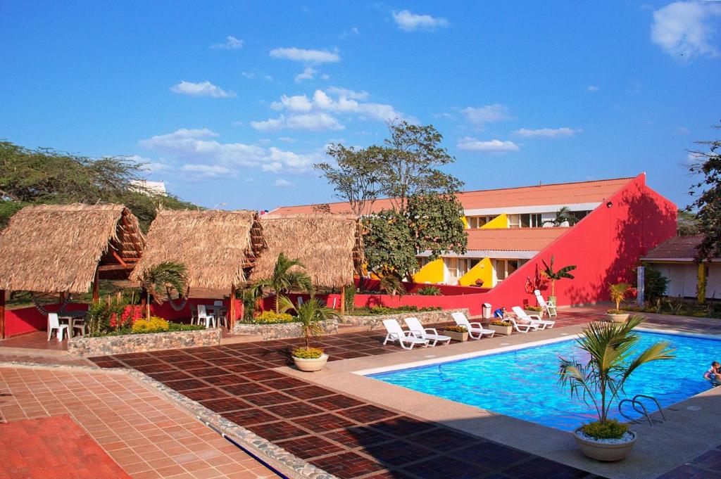 un complexe avec une piscine à côté d'un bâtiment dans l'établissement Hotel Gimaura, à Ríohacha