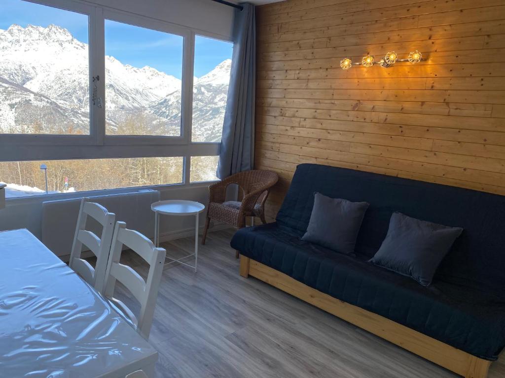 een woonkamer met een bank en een tafel bij Studio Puy Saint Vincent 1600 aux pieds des pistes in Puy-Saint-Vincent