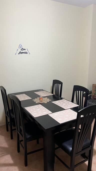 una mesa de comedor negra con sillas negras en Budget Beach Apartment 35% Discount, en Durrës