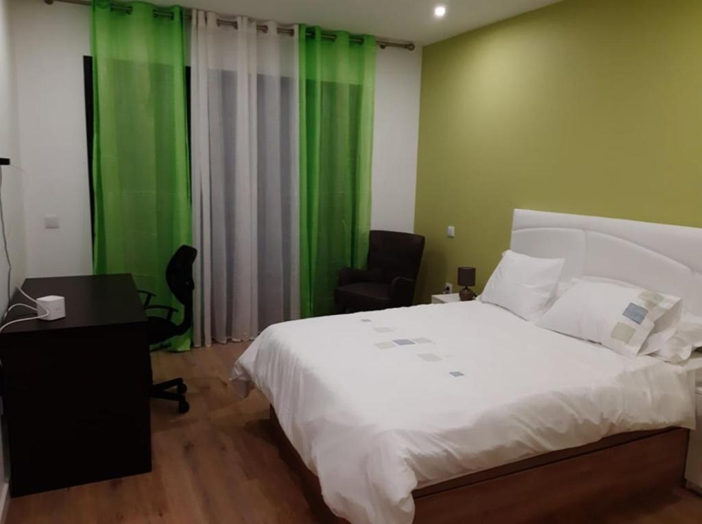 una camera con un letto bianco e una parete verde di spacious 2 bedroom holiday home torre villas d a Machico
