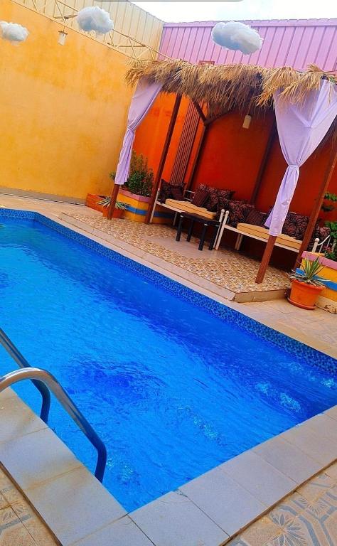 a large blue swimming pool next to a building at شاليهات الدرب ليله دورين in Qarār