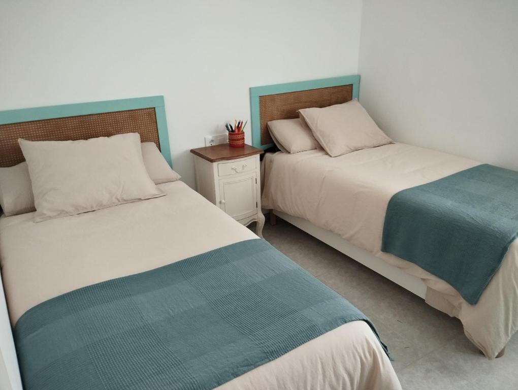 twee bedden naast elkaar in een slaapkamer bij LA PONDEROSA BEACH in Sanlúcar de Barrameda