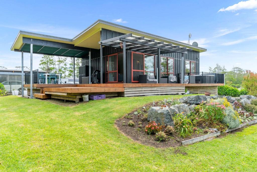 a house with a garden in front of it at Summer Haze - Omaha Holiday Home in Matakana