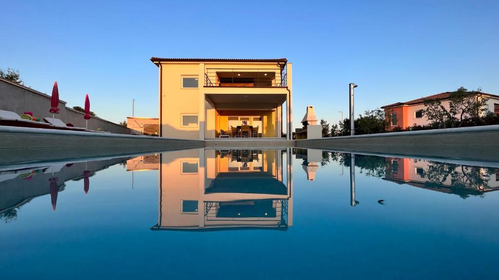 una casa riflette in una piscina d'acqua di Villa Leandra a Vodnjan (Dignano)