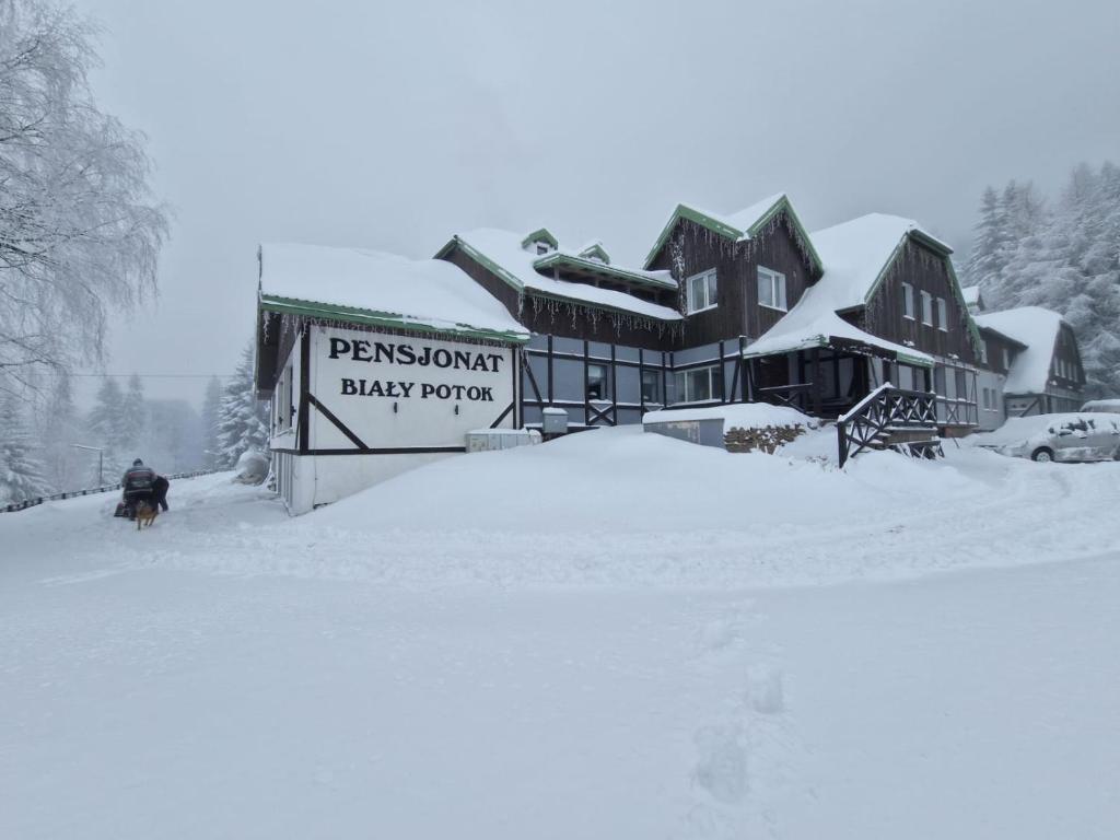 a large building with a sign in the snow at Biały Potok in Zieleniec