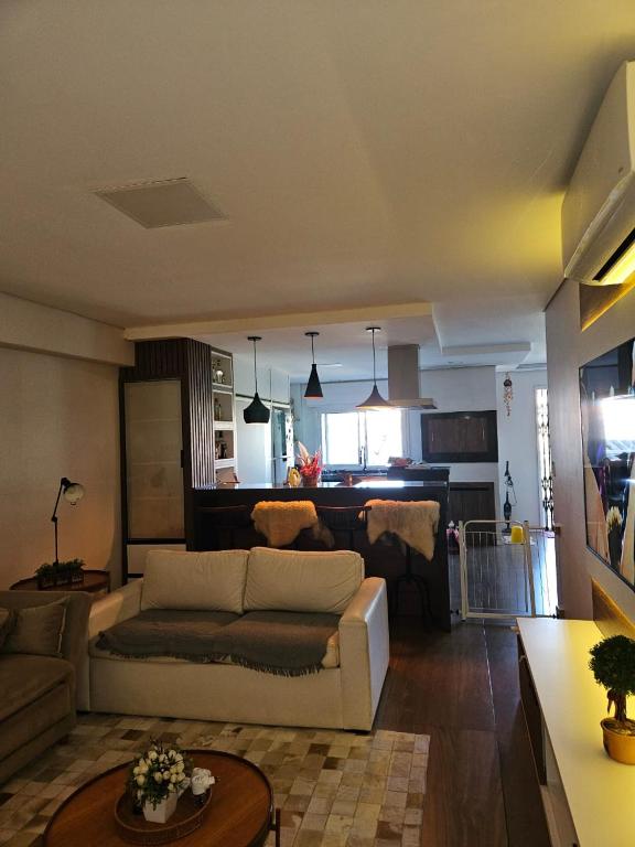 ein Wohnzimmer mit einem Sofa und einem Tisch in der Unterkunft Apartamento Alto Padrão Uruguaiana in Uruguaiana