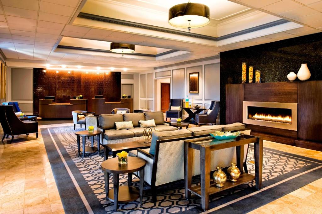 een lobby met een bank en een open haard bij Sheraton Framingham Hotel & Conference Center in Framingham