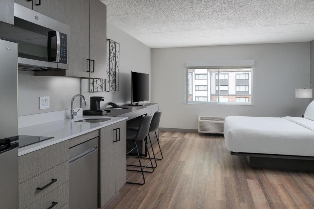 a kitchen and living room with a bed in a room at TownePlace Suites by Marriott Framingham in Framingham