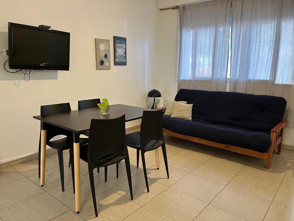 布宜諾斯艾利斯的住宿－Cómodo PH con patio propio，客厅配有桌子和蓝色沙发