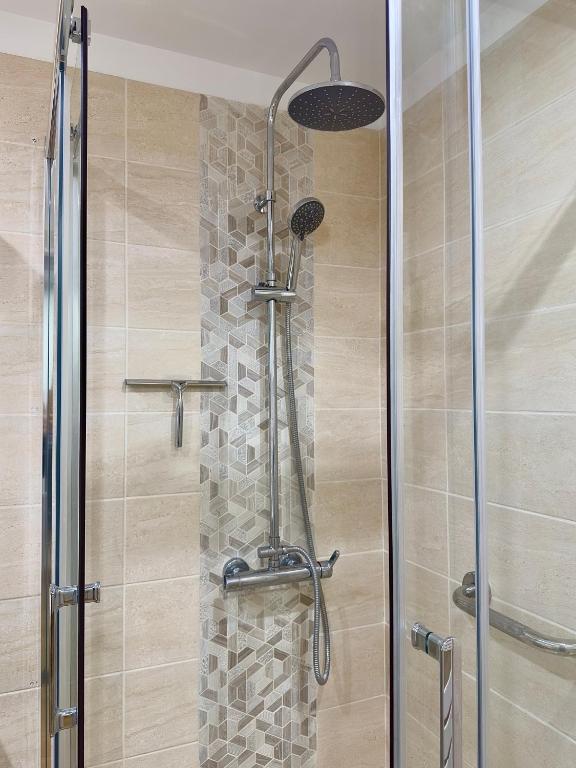 a shower with a glass door in a bathroom at Au Charme De Bussy - Golf 5 mins, Disneyland 10 mins, Paris 15 miles in Bussy-Saint-Georges