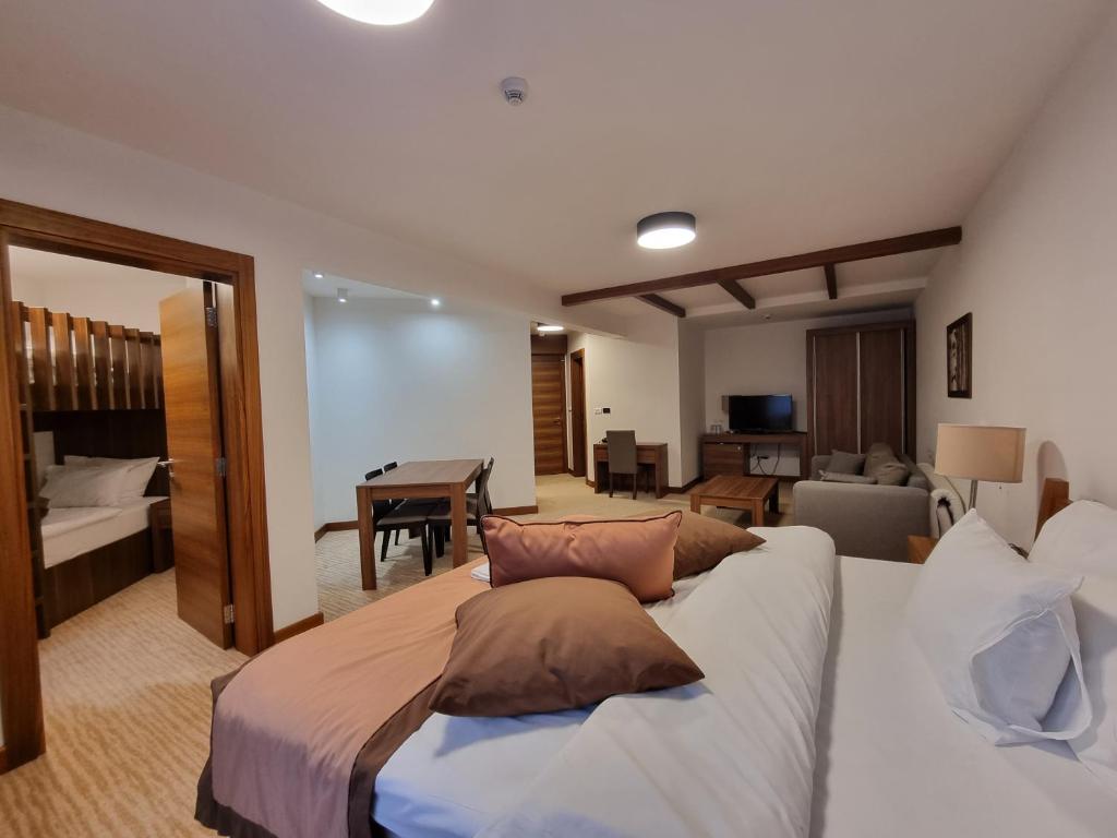 a bedroom with a large bed and a living room at Apartman Queen Vučko in Jahorina