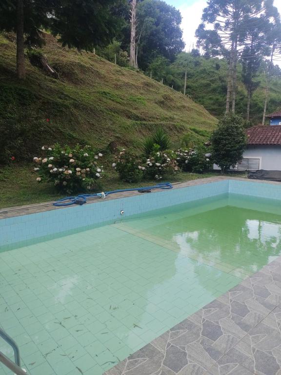 een leeg zwembad met een heuvel op de achtergrond bij Pousada Uai in Alagoa