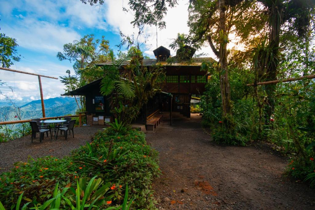 une maison avec une table et des chaises devant elle dans l'établissement Bellavista Cloud Forest Lodge & Private Protected Area, à Tandayapa
