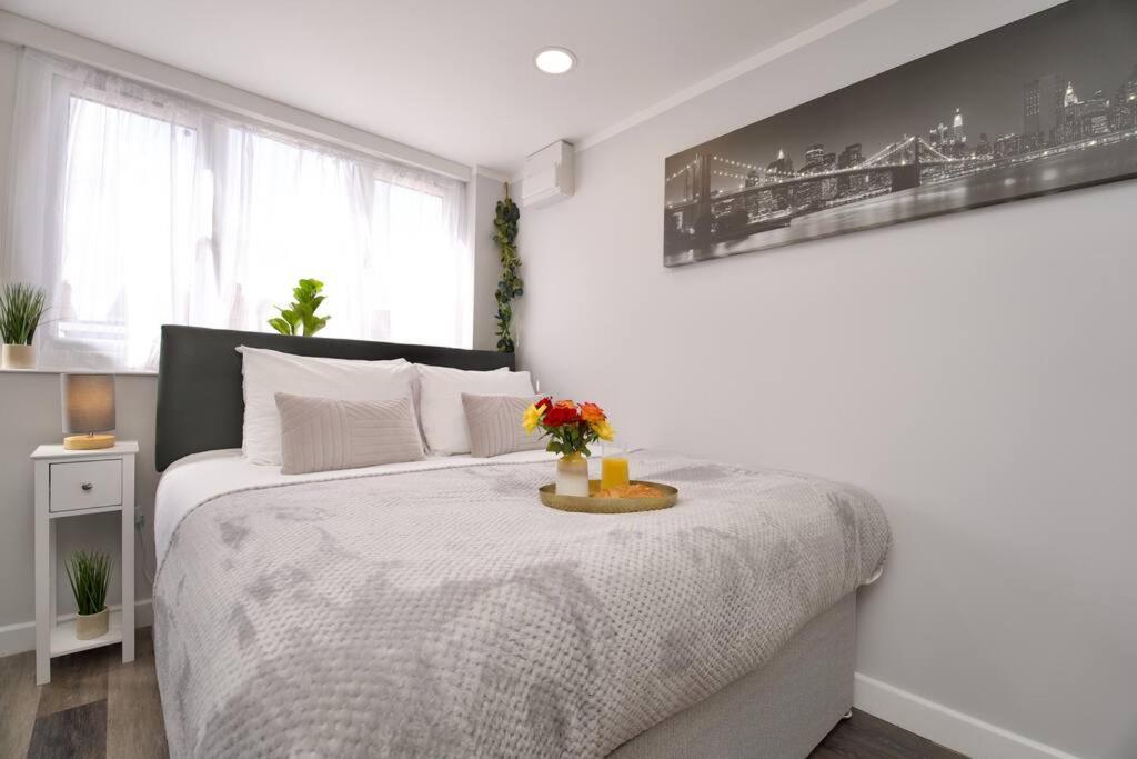 a white bedroom with a bed with flowers on it at Dane Duplex Studio 8 – Coventry in Coventry