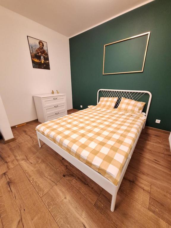 um quarto com uma cama com um cobertor xadrez em Apartament Golda em Toruń