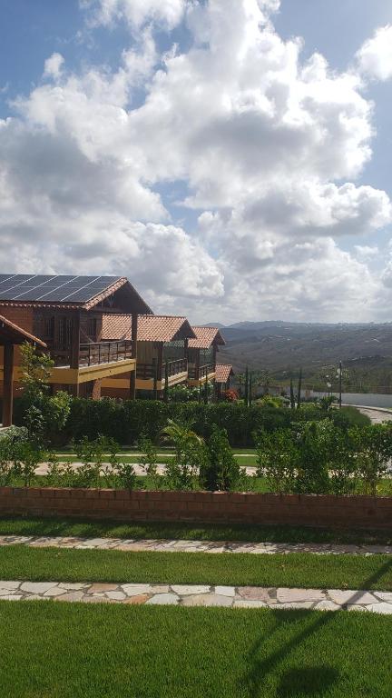 a house with a roof with a view of a field at Casa de Campo Novo gravatá em condomínio, lazer completo com piscina compartilhada, churraqueira e forno a lenha privado e uma vista espetacular e com aquele friozinho in Gravatá