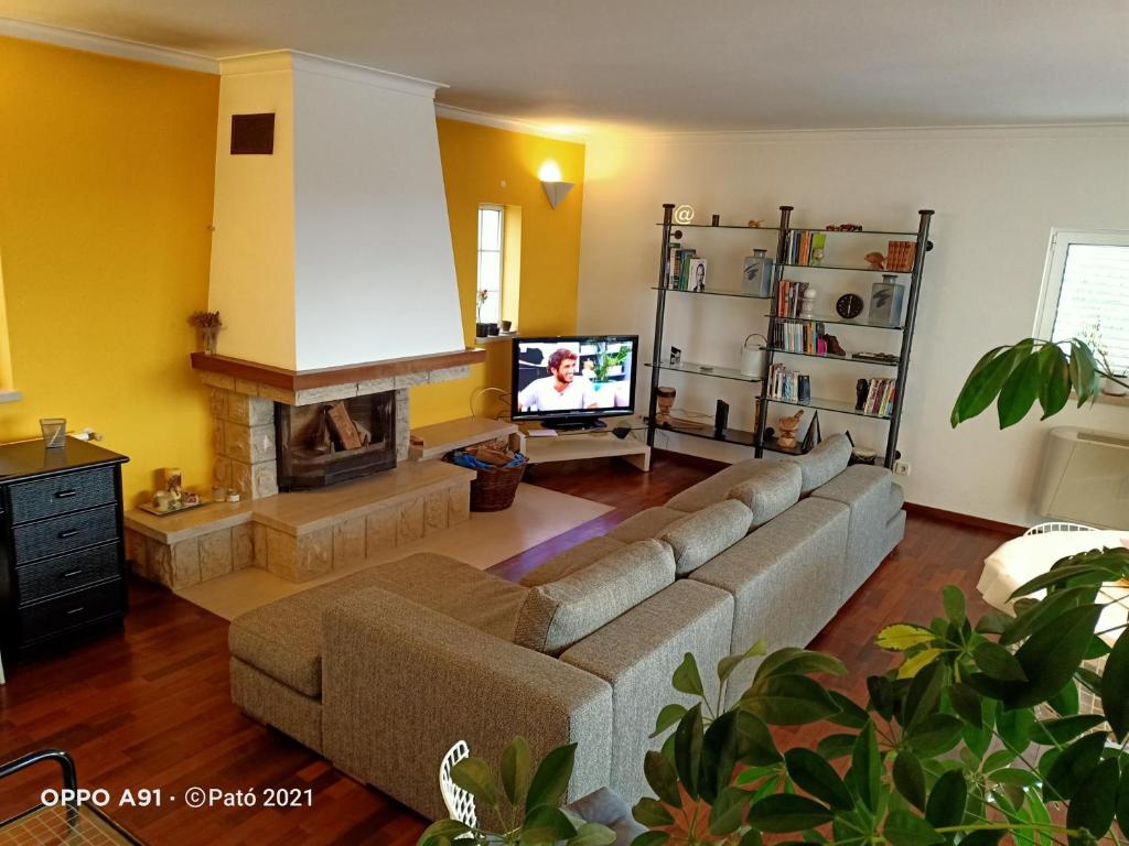 uma sala de estar com um sofá e uma televisão em Leiria Fatima Nazaré 3 Bedroom House em Leiria